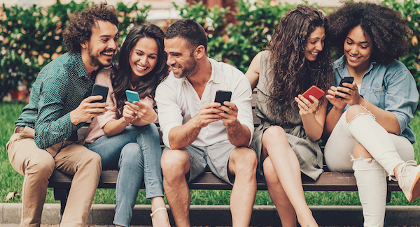 Group of Friends on Bench Looking at Phones